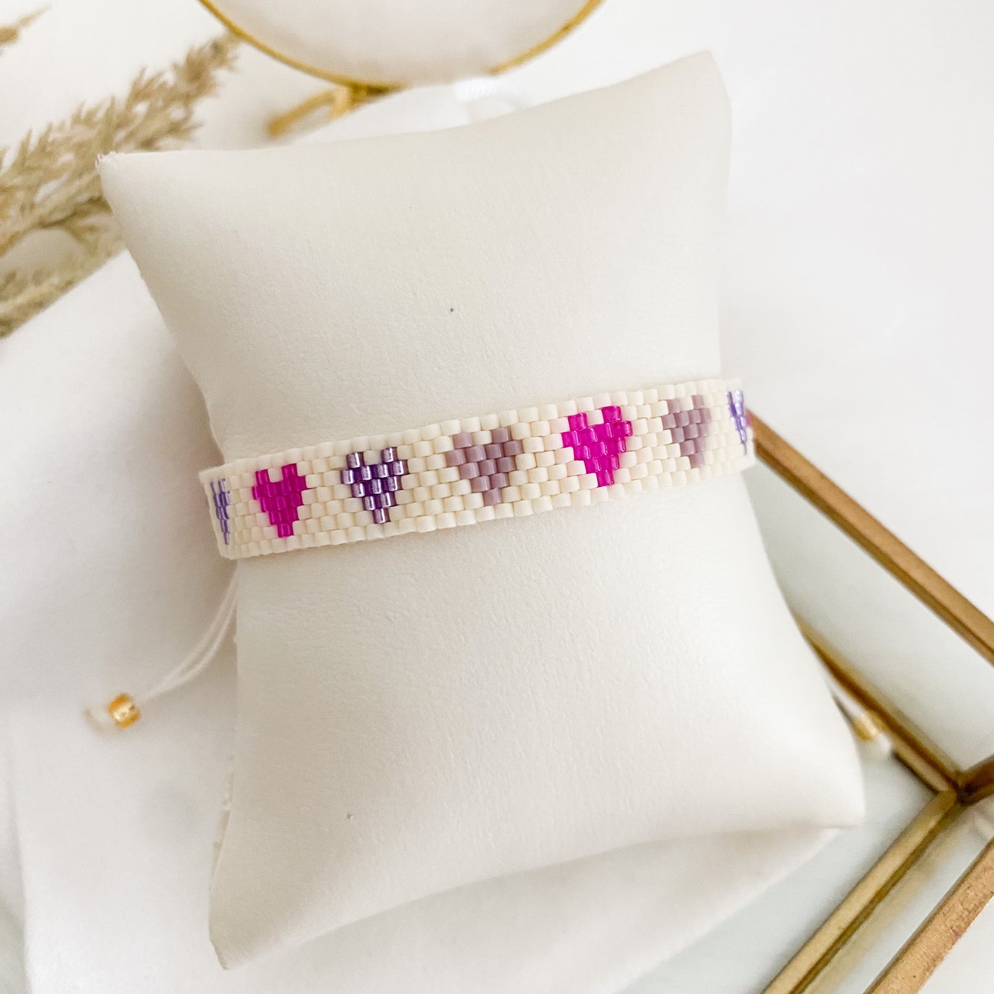 White bracelet with purple hearts