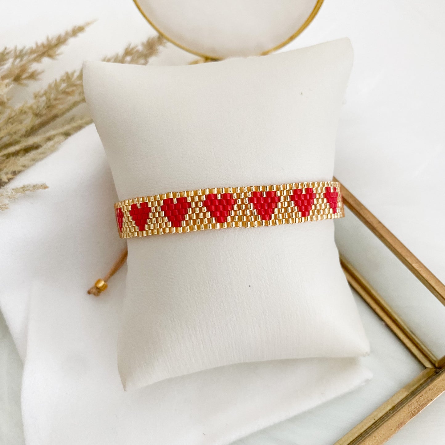 Gold bracelet with red hearts